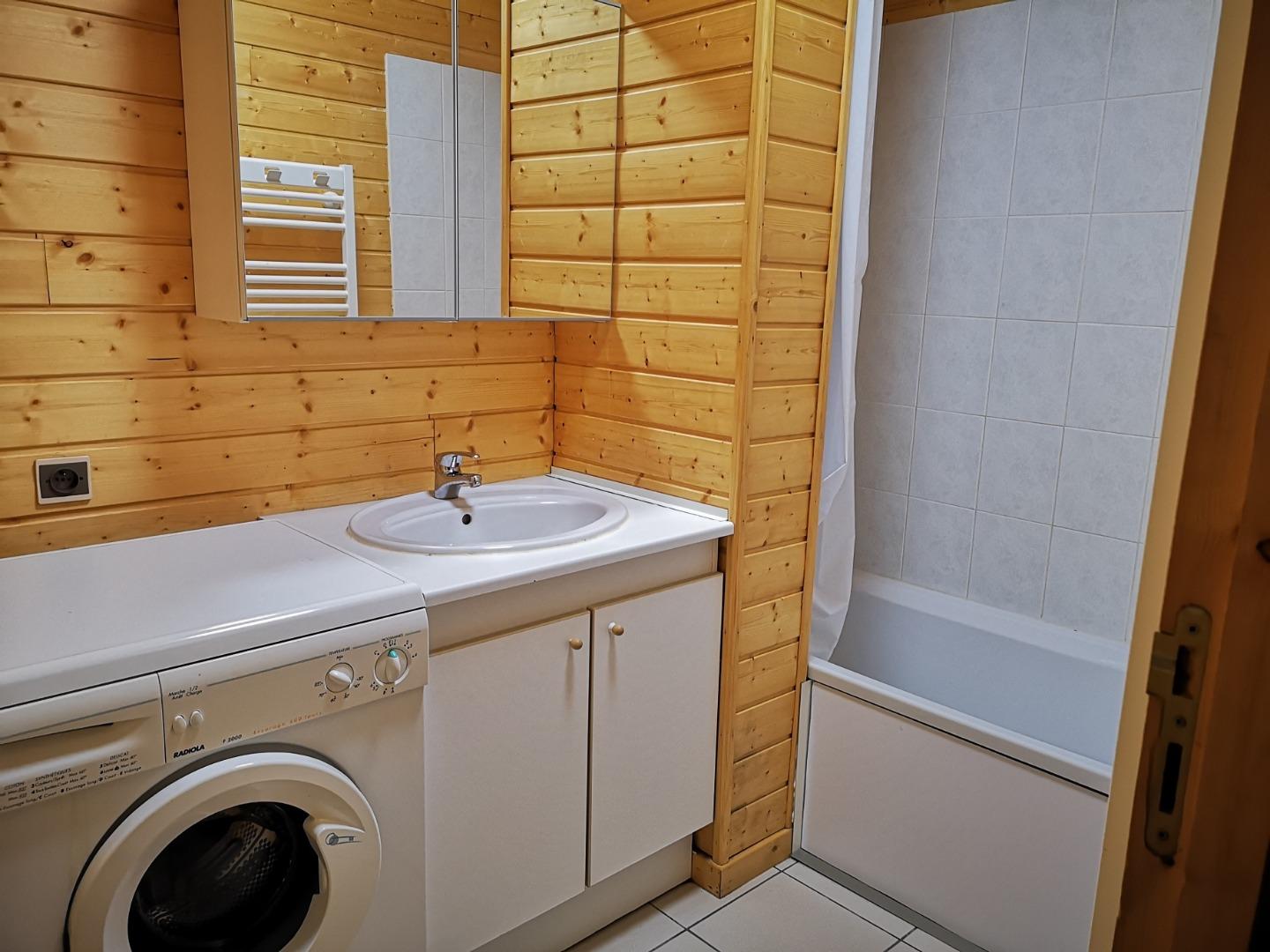 Salle de bain avec machine à laver le linge