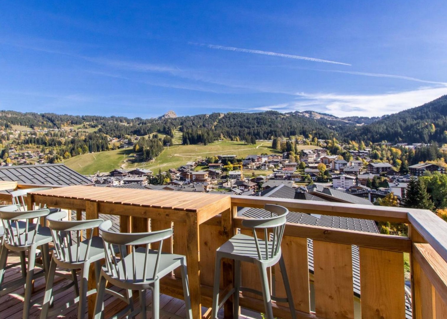 Vue panoramique de la terrasse sud, équipée de tables et chaises hautes .