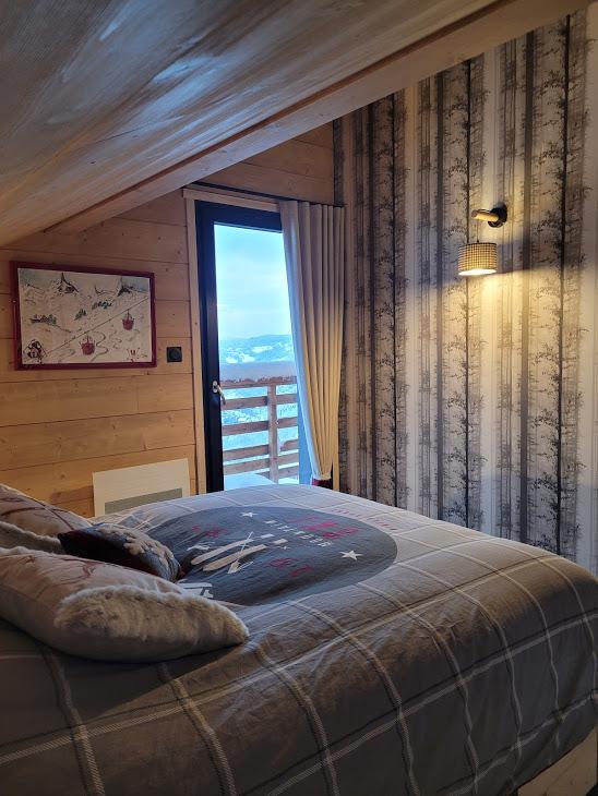 chambre étage Les Marmottes 8m2 : lit 140x200 ,penderie , coffre , deux tiroirs dans le lit , literie super confort , porte fenêtre sur balcon avec vue sur les montagnes, plein sud  .