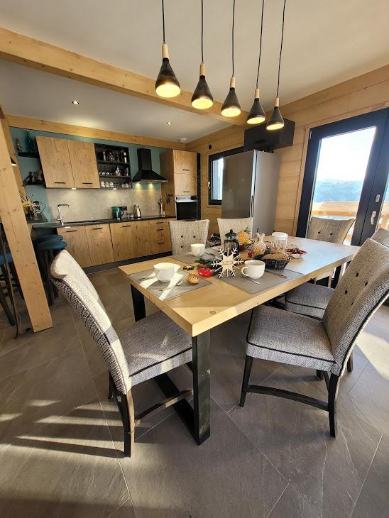 coin séjour ,ouvert sur cuisine , table massive bois ,accès balcon et terrasse avec vus sur les montagnes plein sud ,