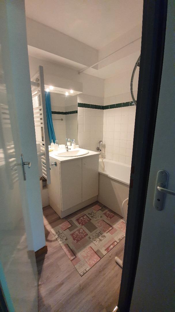 Salle de bain avec lavabo et sèche serviettes
