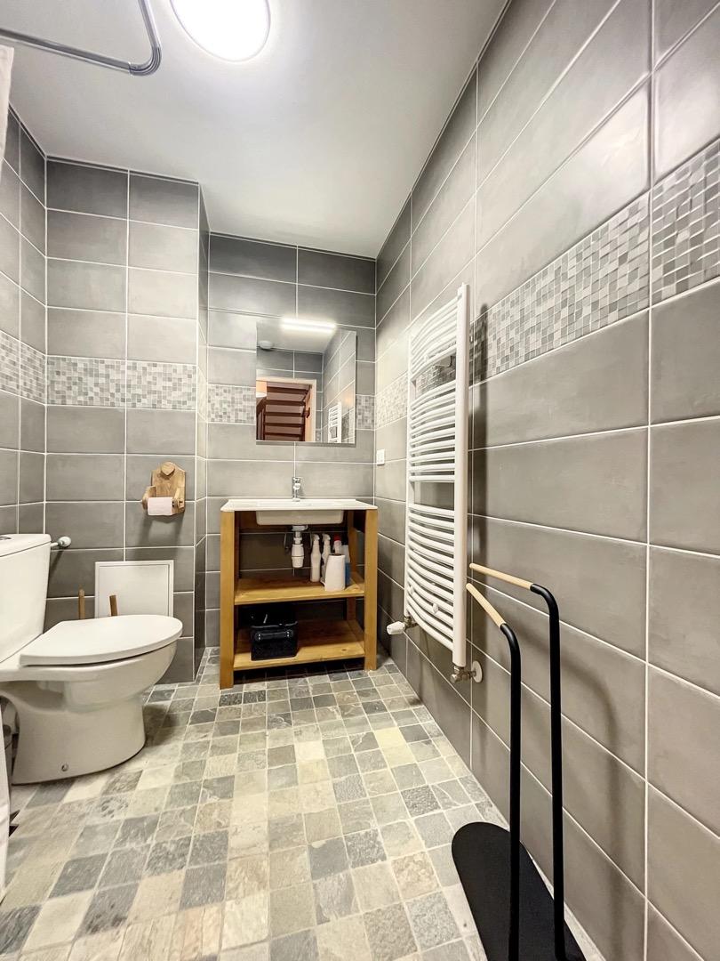 Salle de bain avec toilettes et douche à l'italienne.