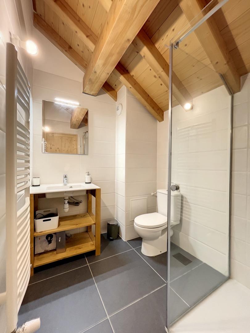 Salle de bain avec toilettes et douche à l'italienne.