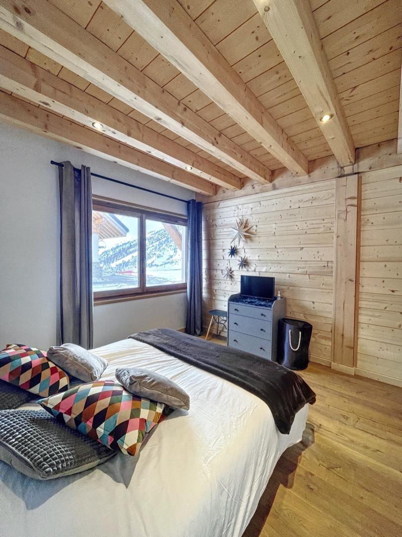 Chambre du rez-de-chaussée avec lit double et télévision.