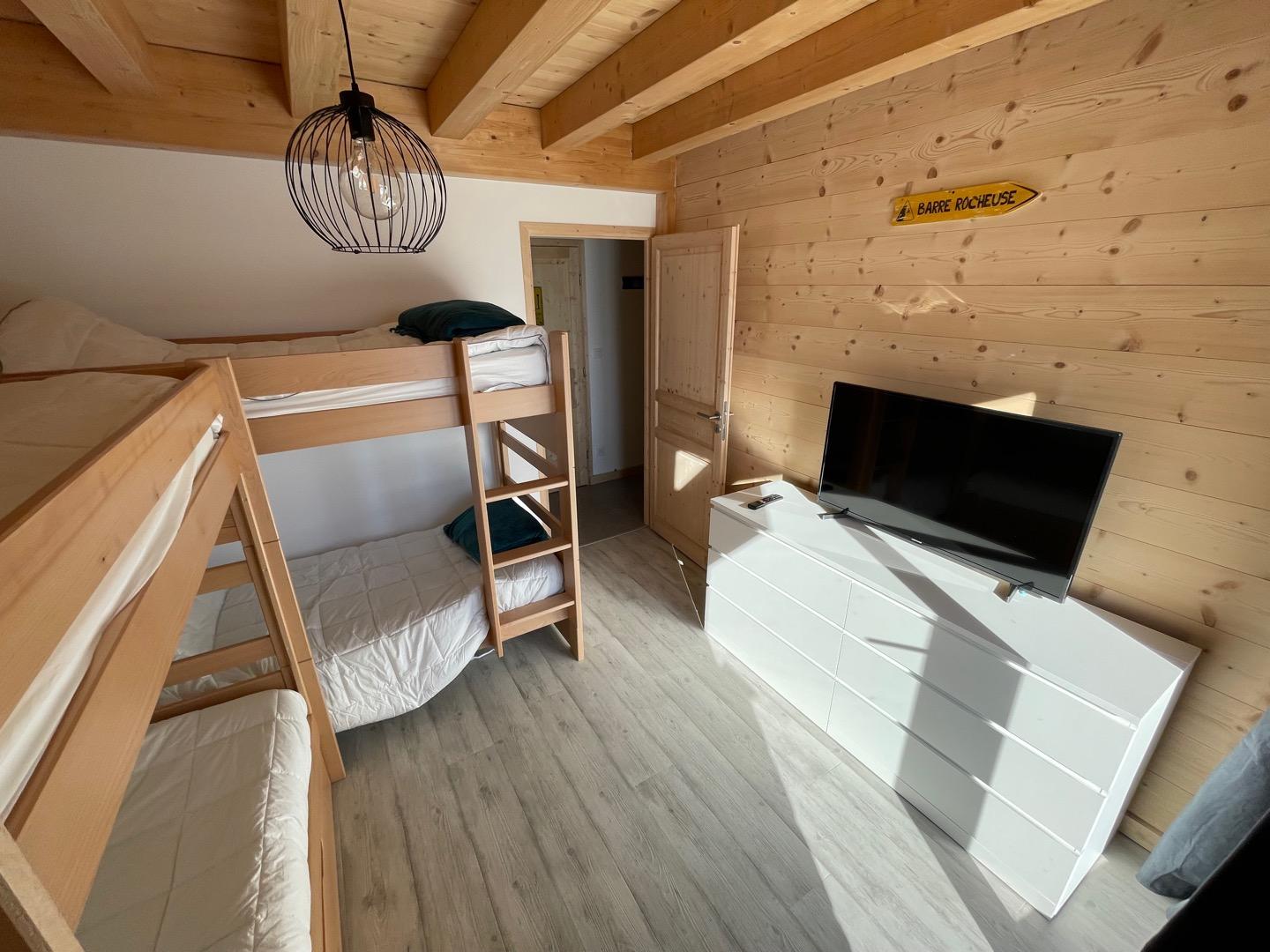 Deuxième chambre du rez-de-chaussée avec lits superposés et telévision.
