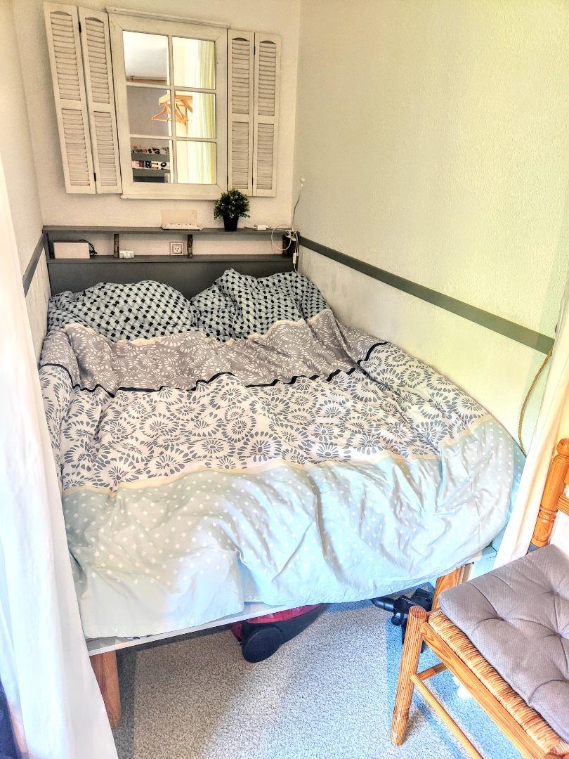 Lit double dans alcove protégée par un rideau