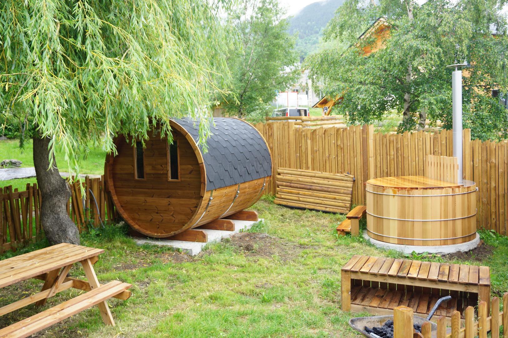 jardin avec table de pique-nique, sauna tonneau acessible en libre-service (compris dans le prix) pour 6 personnes.
On voit un bain nordique sur la photo mais suite à de mauvaises utilisations, on a du le condamner.Il n'est donc plus utilisable.