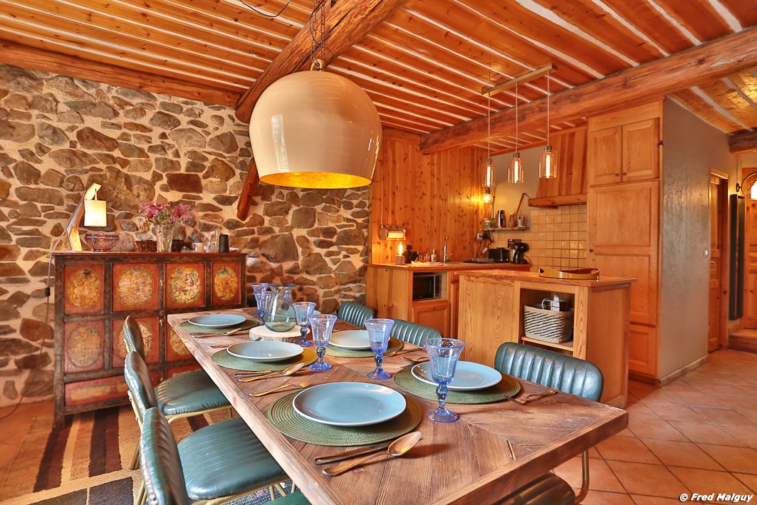 Depuis la table repas, vue sur buffet-vaisselier, cuisine ouverte et couloir d'accès