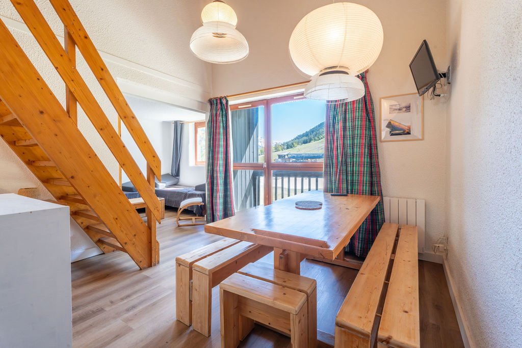 Vue de la pièce principale et du balcon qui donne directement sur les pistes (hiver) / terrains de tennis (été)