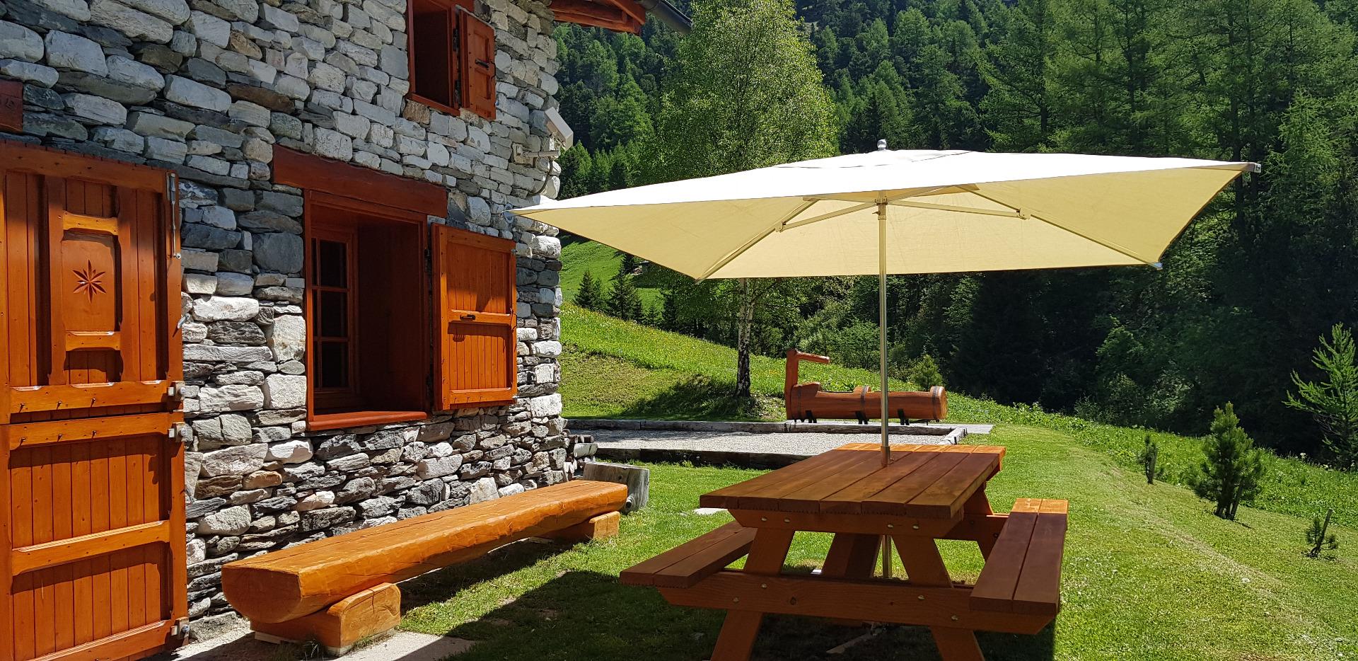 Grande table avec barbecue pour vos repas à l'extérieur.