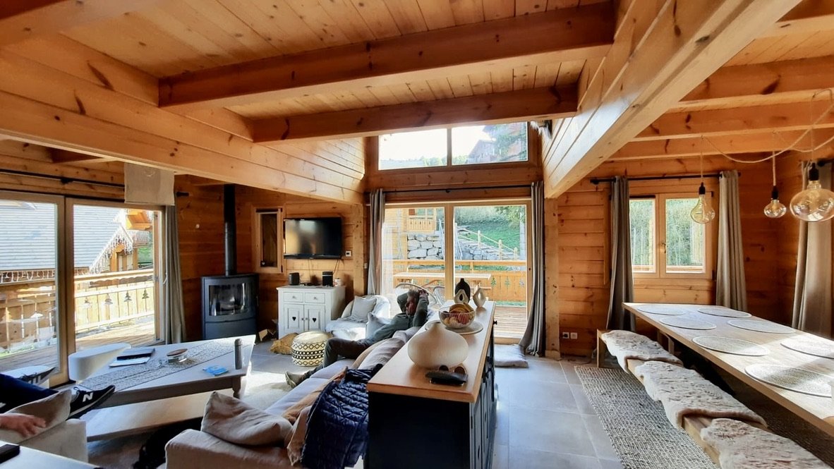 Le séjour est spacieux, convivial et lumineux. Il ouvre par de larges baies vitrées sur une grande terrasse qui fait quasi le tour du chalet.Un poêle à bois très facile d'utilisation viendra réchauffer la pièce et créer une belle atmosphère.