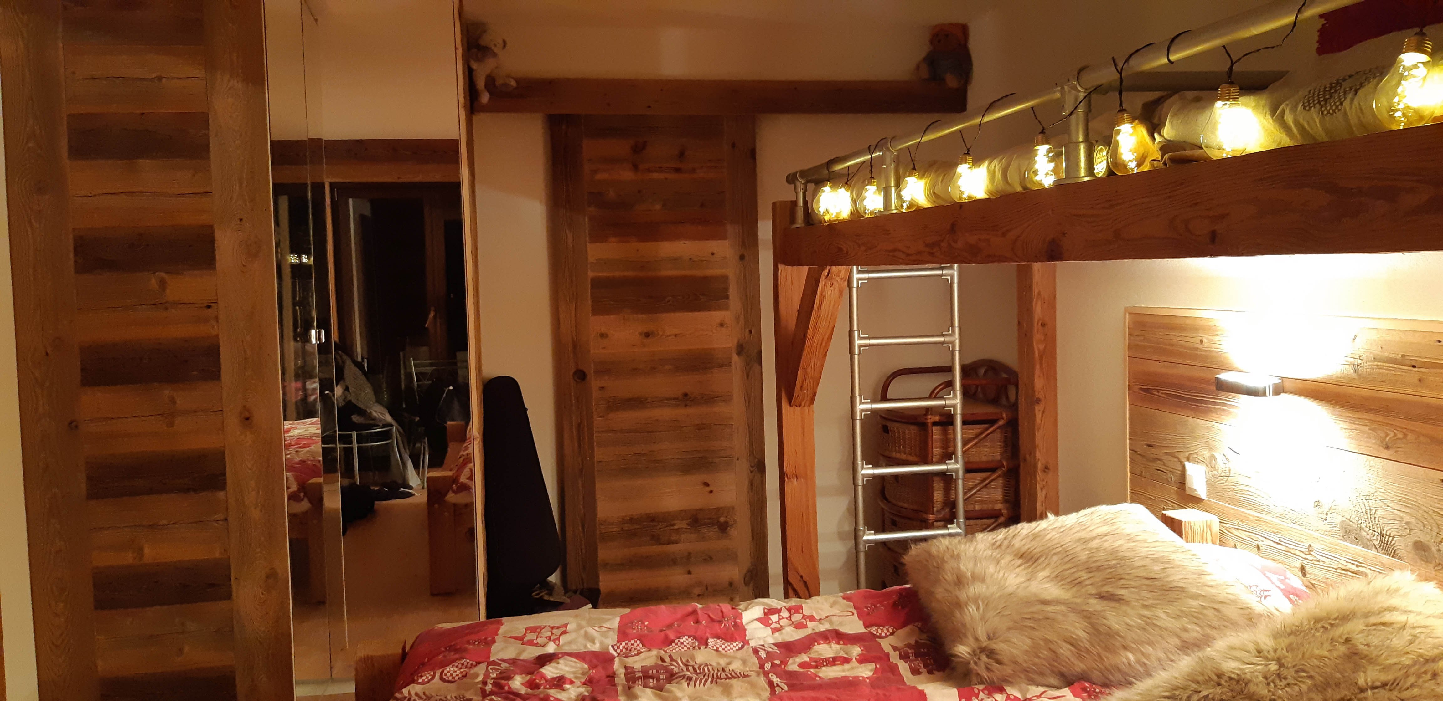 Chambre 1, en bas avec un lit double (queen size) et 2 lits simples au-dessus accessibles par une échelle. Une salle de bain privative (baignoire/douche, vasque, WC).