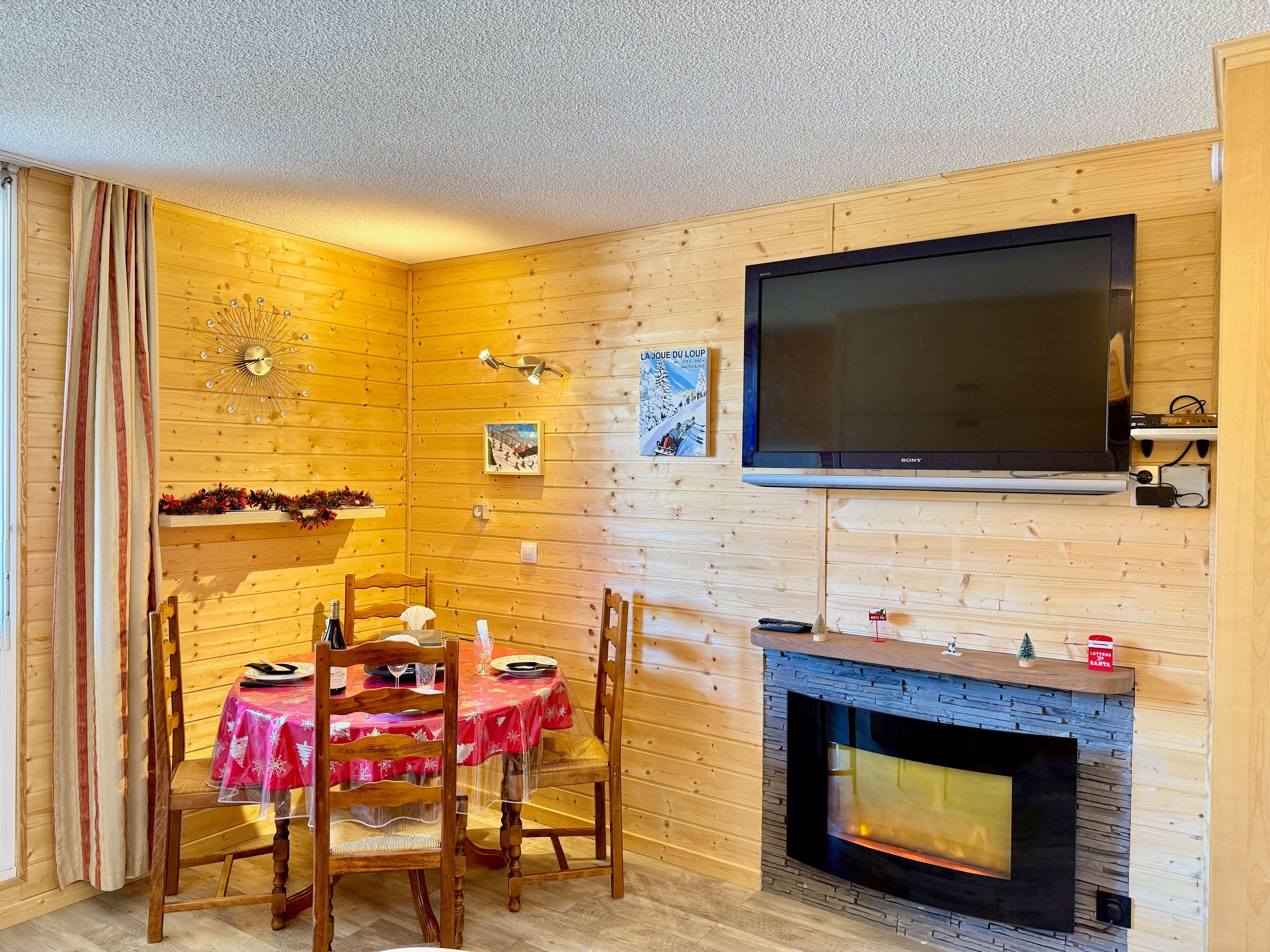 Espace repas avec grande TV, chaines TNT, WiFi (4G) et cheminée électrique