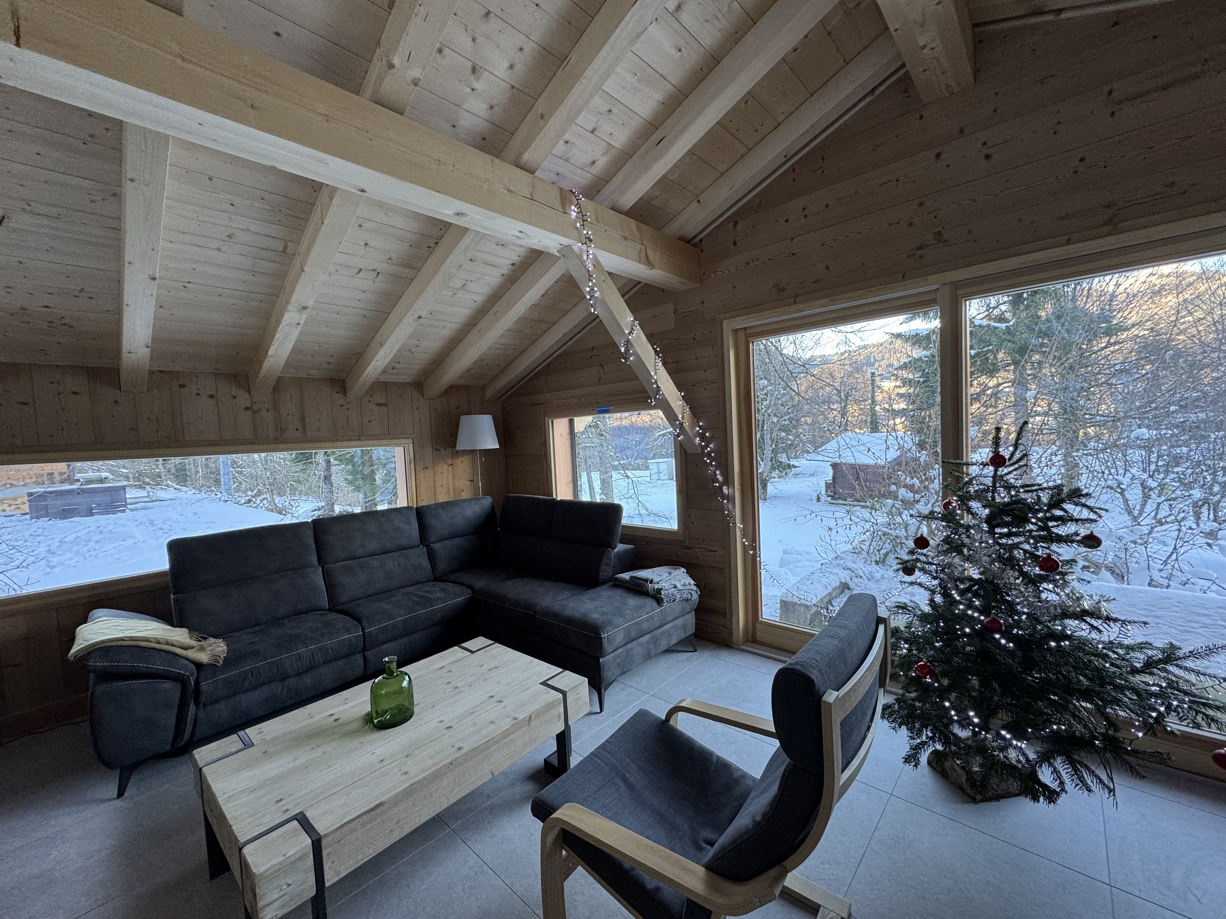 Ambiance hivernale : relaxez-vous dans un grand canapé confortable, avec vue sur la montagne !
Le salon comporte 1 grand canapé d'angle, 2 fauteuils, 1 table basse et un coin télé. 