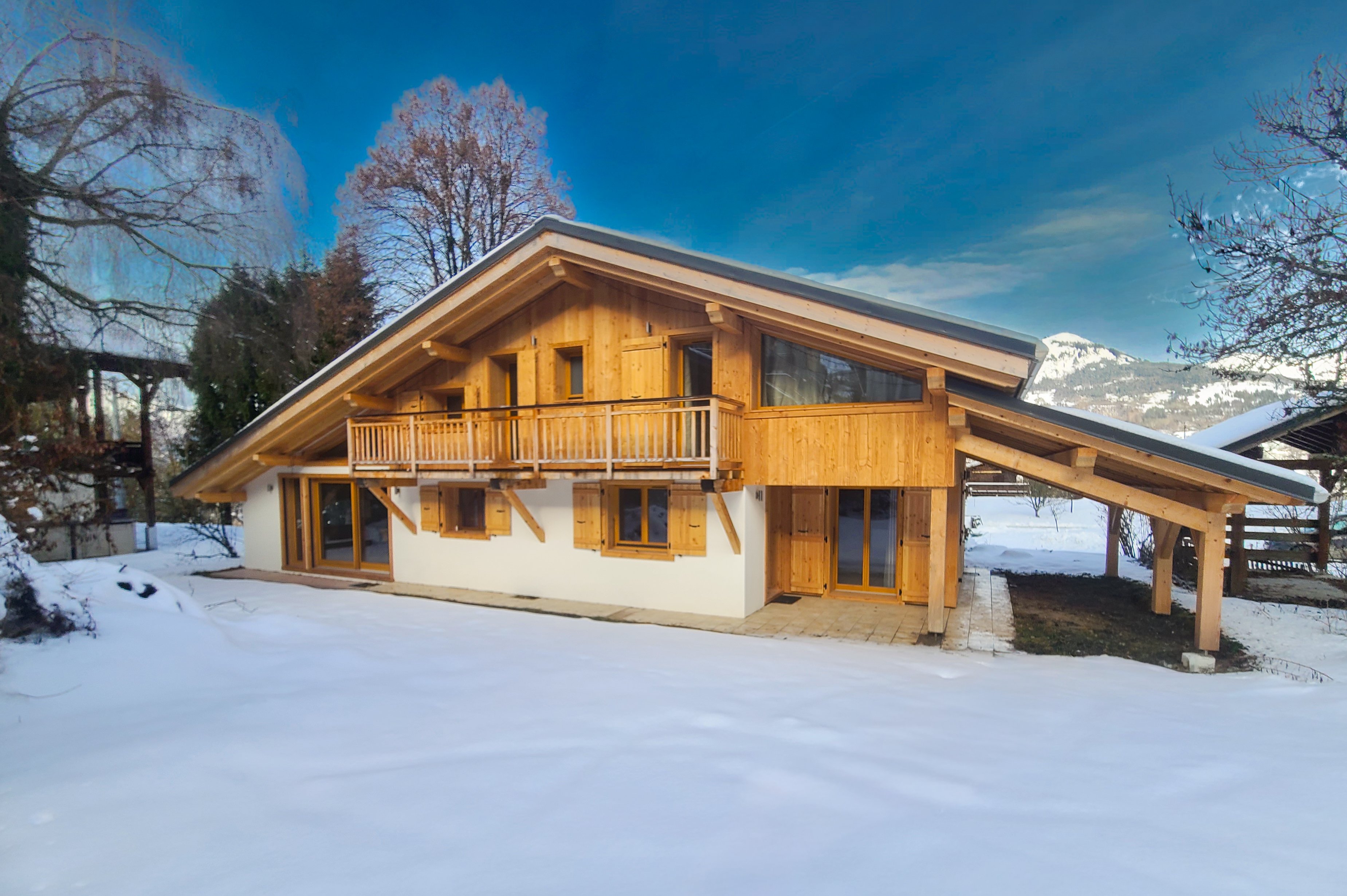 Extérieur du chalet sous la neige, avec les montagnes en toile de fond