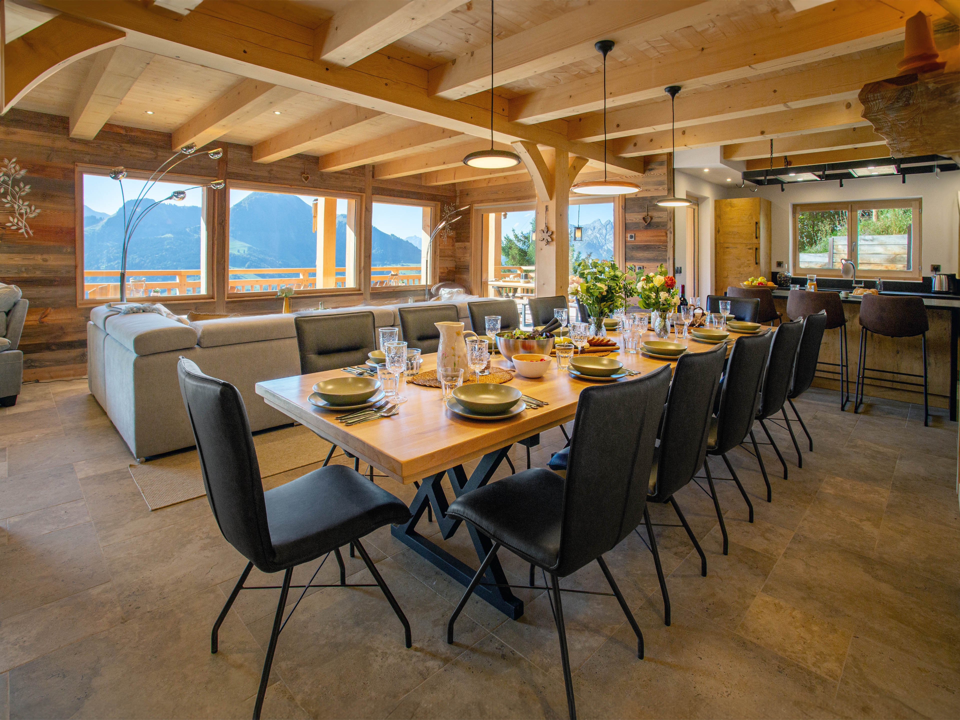 Grande table conviviale avec vue panoramique sur les Alpes. Un espace élégant et lumineux, idéal pour partager des repas en famille ou entre amis, tout en profitant d’un cadre exceptionnel.