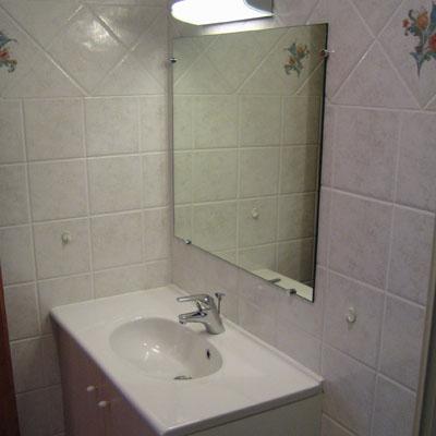 salle de bain avec lavabo et meuble integré, miroir, radiateur seche serviette, douche