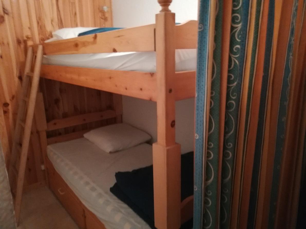 Cabine 6m2 avec un rideau, isolée du séjour par une porte :  2 lits superposés (2x90) (lit supérieur interdit enfant -6ans), échelle en bois fixe, placard-penderie, 2 tiroirs de rangement sous le lit, literie avec couettes, oreillers 65x65, protège literi