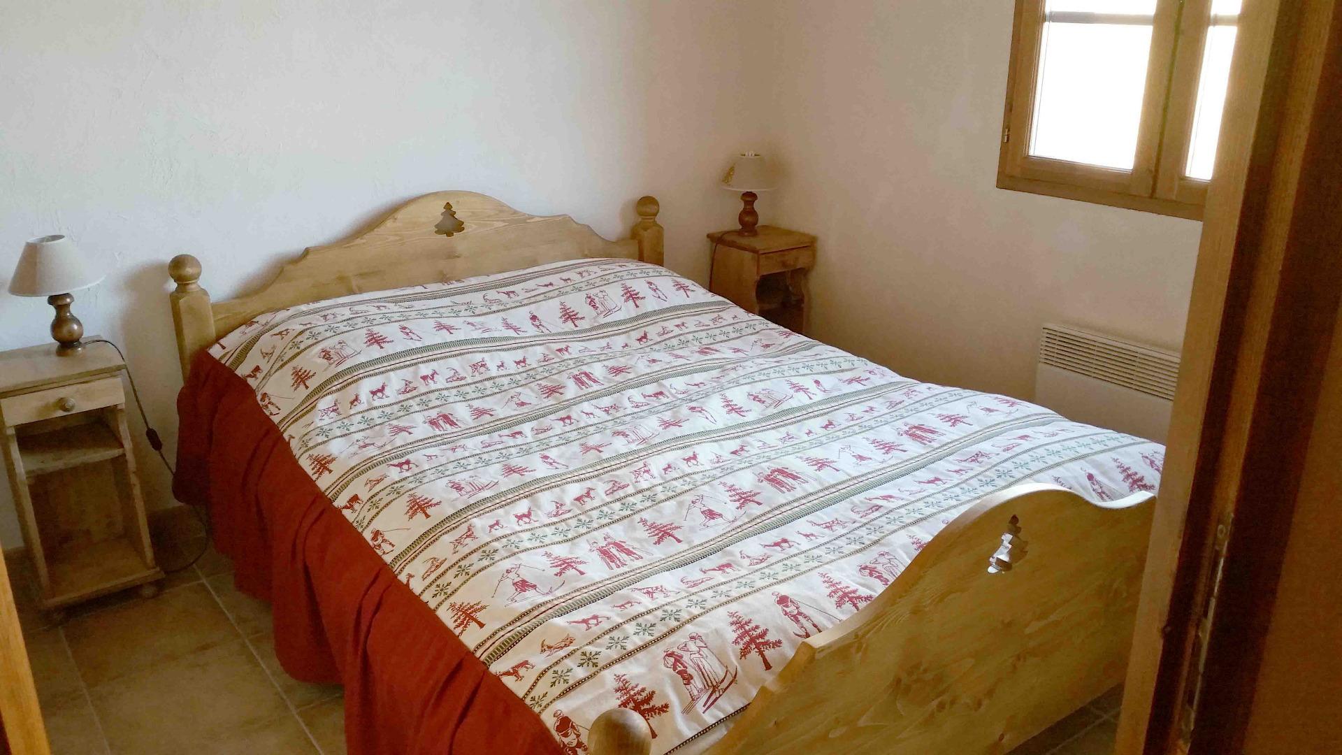 Chambre "Montagne" avec lit de 140 et tables de nuit en rez de chaussée, placard encastré avec penderie et meuble de coin