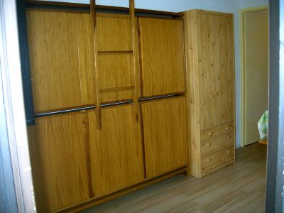 2 lits superposés repliables contre le mur + armoire de rangement dans le fond de la pièce