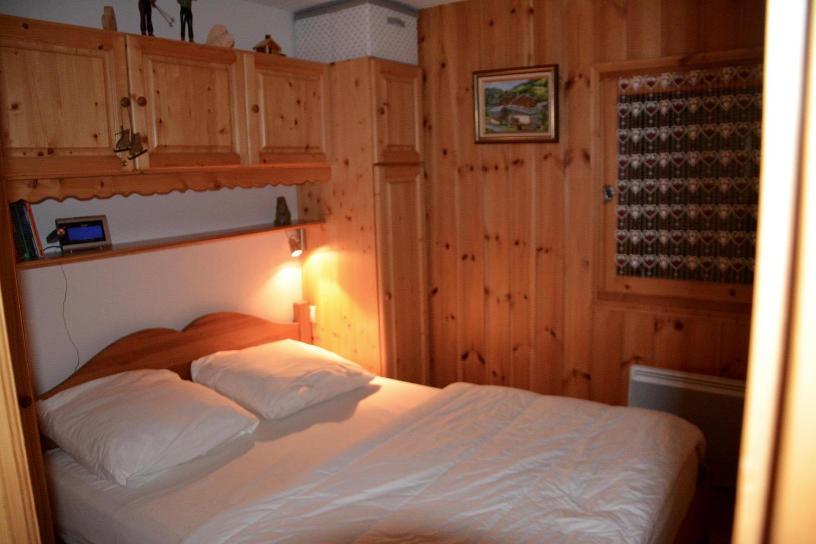 Chambre parentale. Lit de 140cm . Pont de lit avec 2 penderies et étagères.