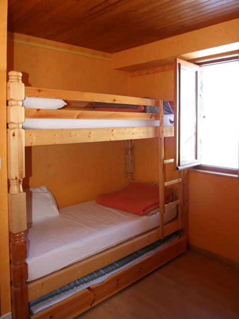 Chambre du rez de chaussée avec lits superposés et un lit tiroir. Armoire de rangement et un bureau. 2 fenêtres orientation ouest et nord.