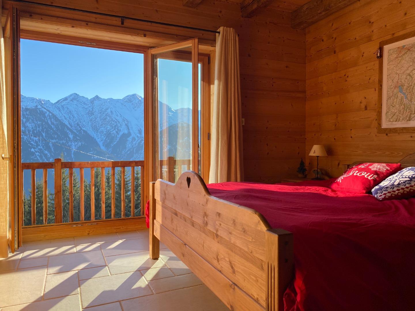 Chambre avec porte fenêtre donnant sur balcon. Superbe vue sur la Pierra Menta et le Mont Mirantin du lit.
