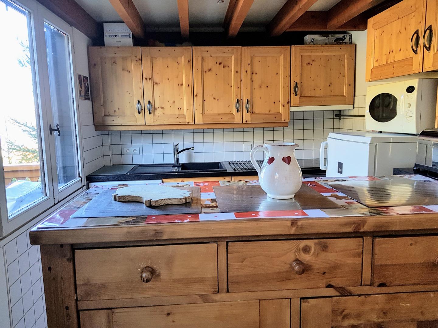 Cuisine americaine s'intégrant au style savoyard.Fenêtre avec belle vue sur la montagne.