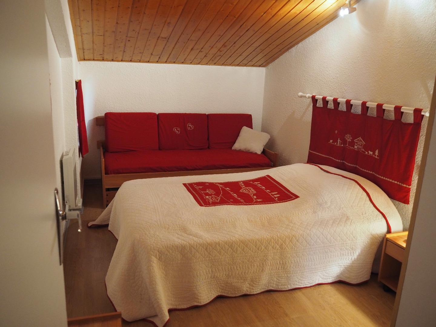 chambre à l'étage avec un lit de deux personnes et un lit d'une personne.
Un lit-parapluie est disponible (il est rangé sous l'armoire).