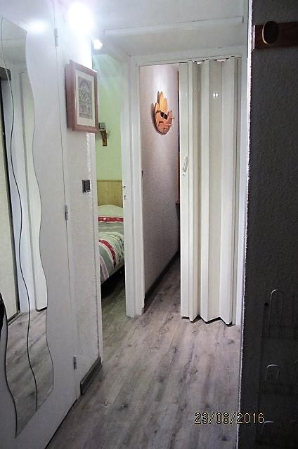 Couloir avec un grand placard de rangement avec étagères et penderie. 