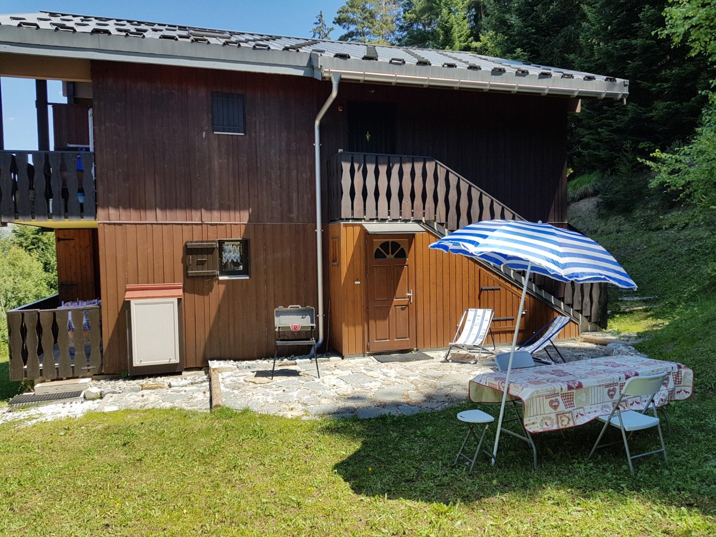 Vue sur le côté de l'appartement (rez de chaussée). sas d'entrée sous le balcon.
En été vous avez à disposition une table,  des chaises , un parasol, un barbecue électrique et 2 transats.