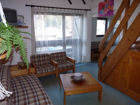 Salon avec baie vitrée sur balcon.