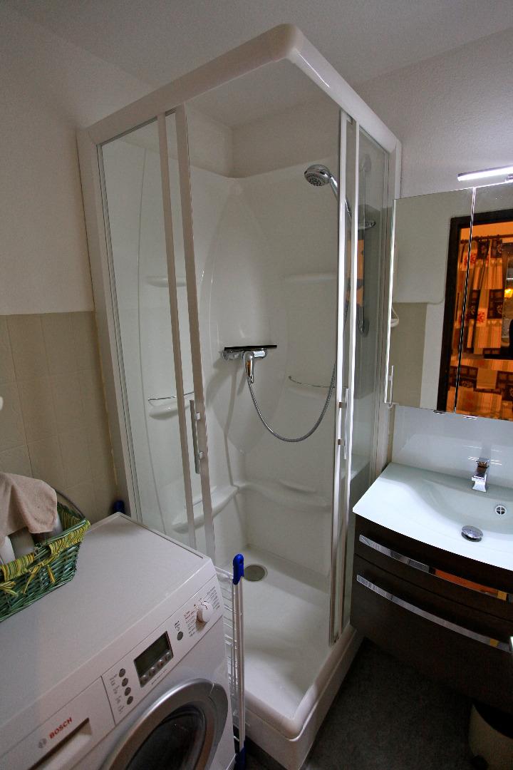 Salle de Douche avec cabine de douche, lavabo et machine à laver séchante. Les toilettes sont à part.