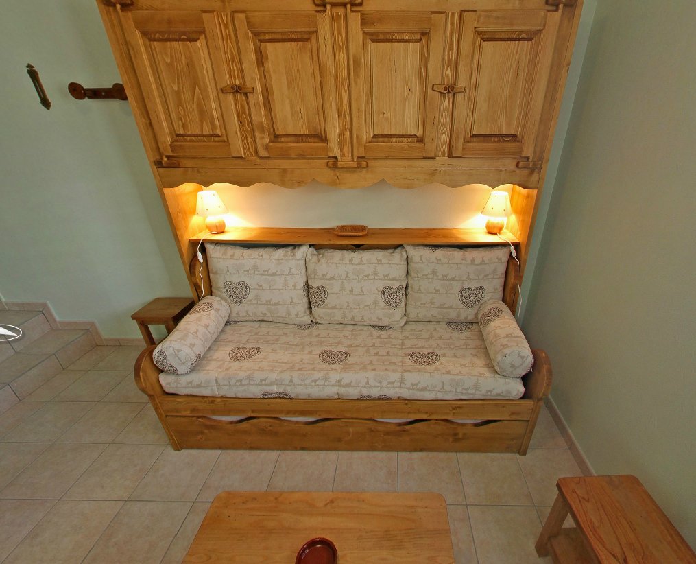 Un salon au rez de chaussée avec une banquette lit gigogne.