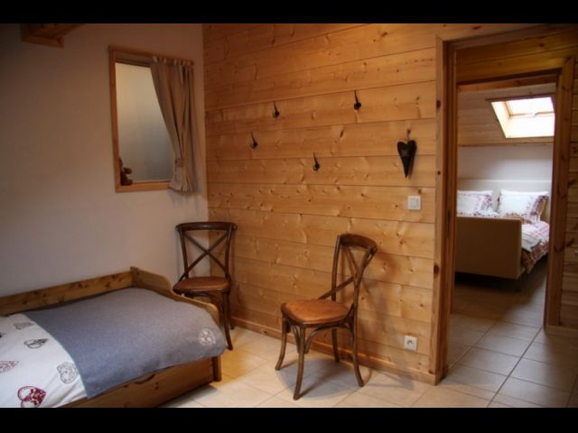 Chambre avec lits simples en premier plan, on aperçoit une des chambres avec lit double