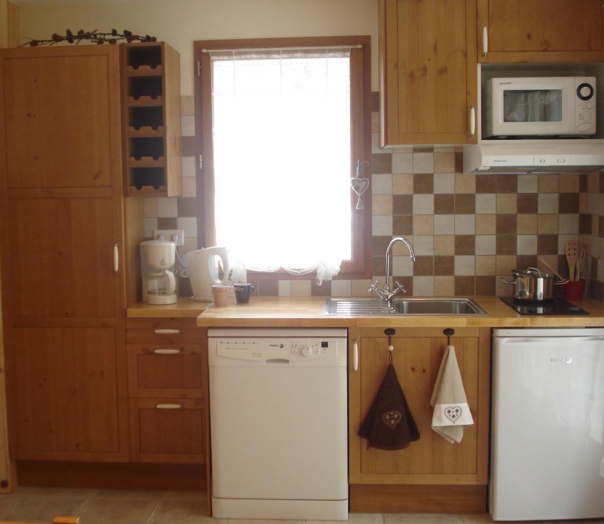 coin cuisine de la location Casareva aménagé avec micro-ondes grill, lave-vaisselle, hotte, plaques vitro, cafetière, bouilloire, frigo table top et vaisselle assortie ...