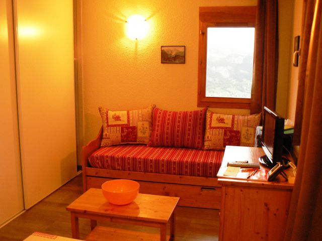 Coin salon avec grand placard, petit meuble de rangement, table basse, télé avec lecteur de DVD.