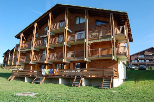 chalet cristal 2 en été. appartement( le 2ème en partant de la droite ) au rez de chaussée avec terrasse/balcon et acces direct extérieur par escalier au premier plan. 