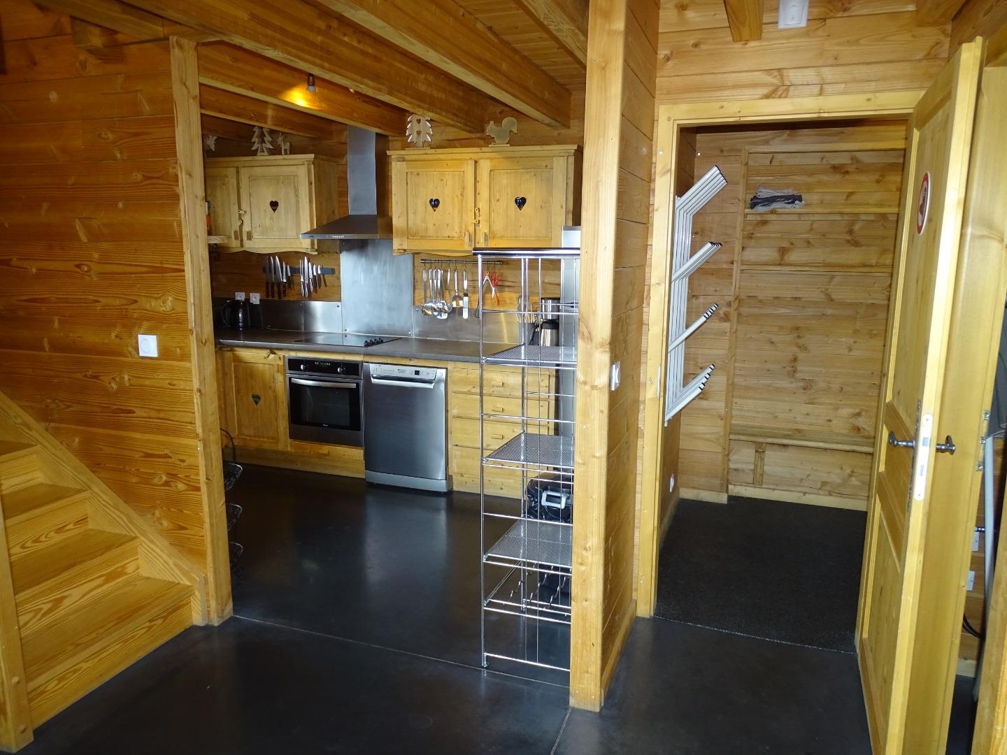 à droite, l'entrée avec les portes chaussures et son banc, 
au centre la cuisine,
à gauche l'accès aux étages