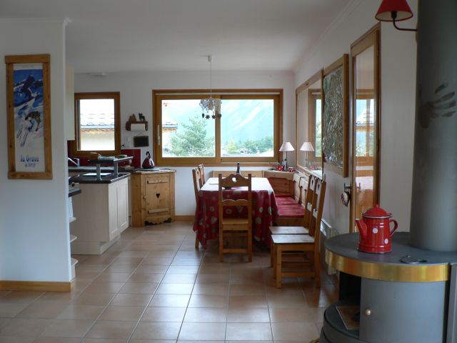 Coin repas exposé sud et est avec  vue village et montagne.Cuisine américaine bien équipée.