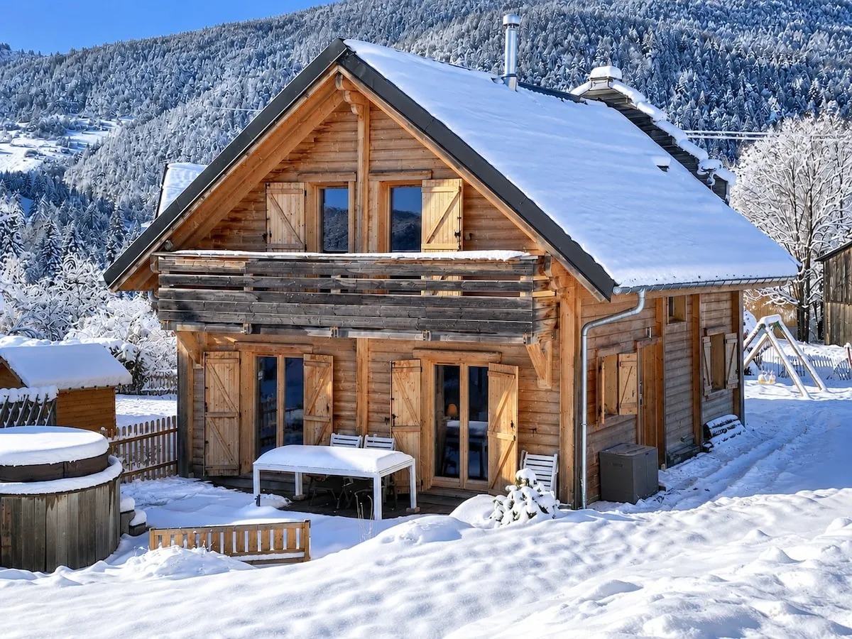 Le chalet sous la neige, avec sa terrasse et son jacuzzi en bois