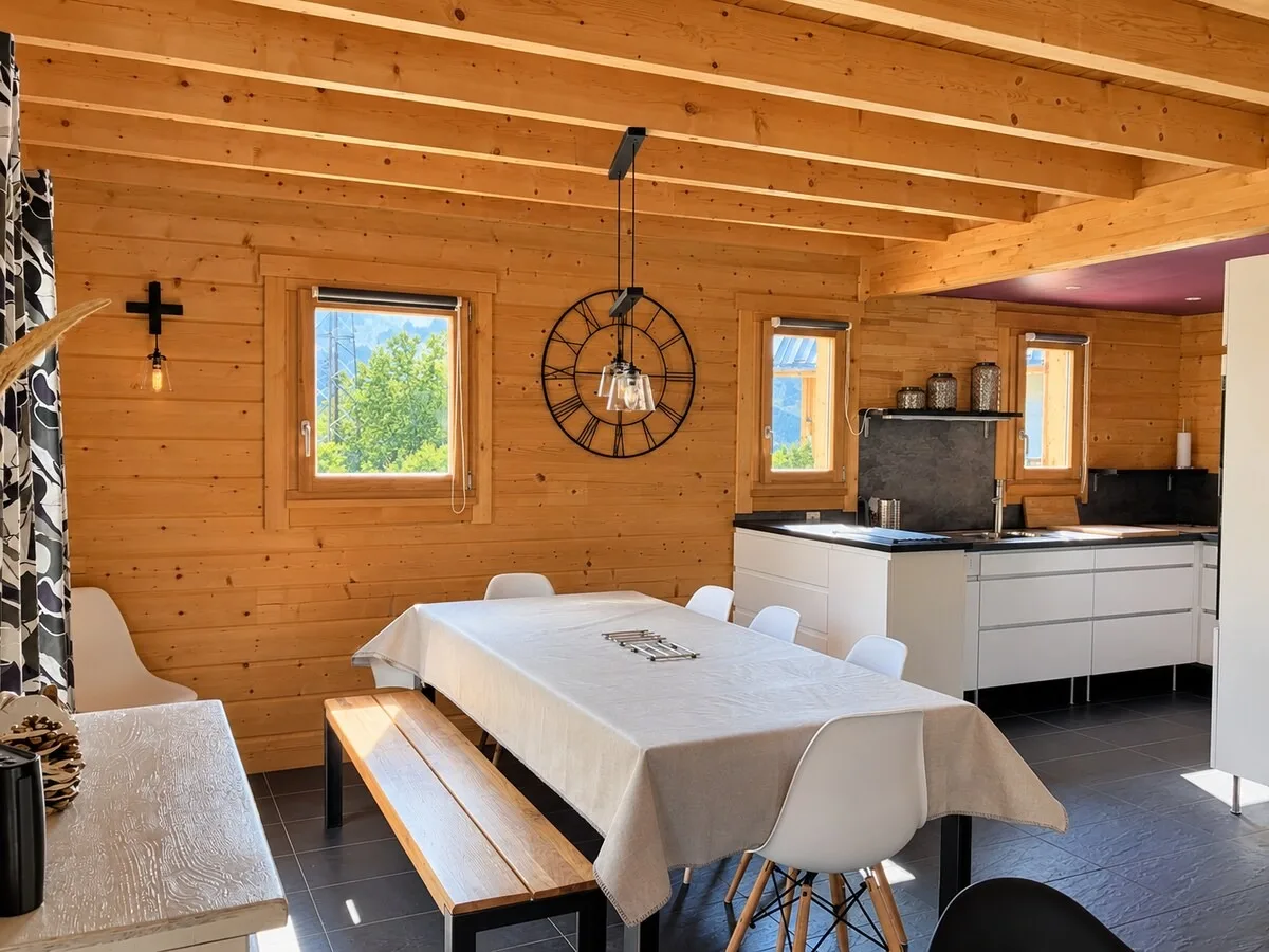 Salle à manger avec grande table, ouverte sur la cuisine