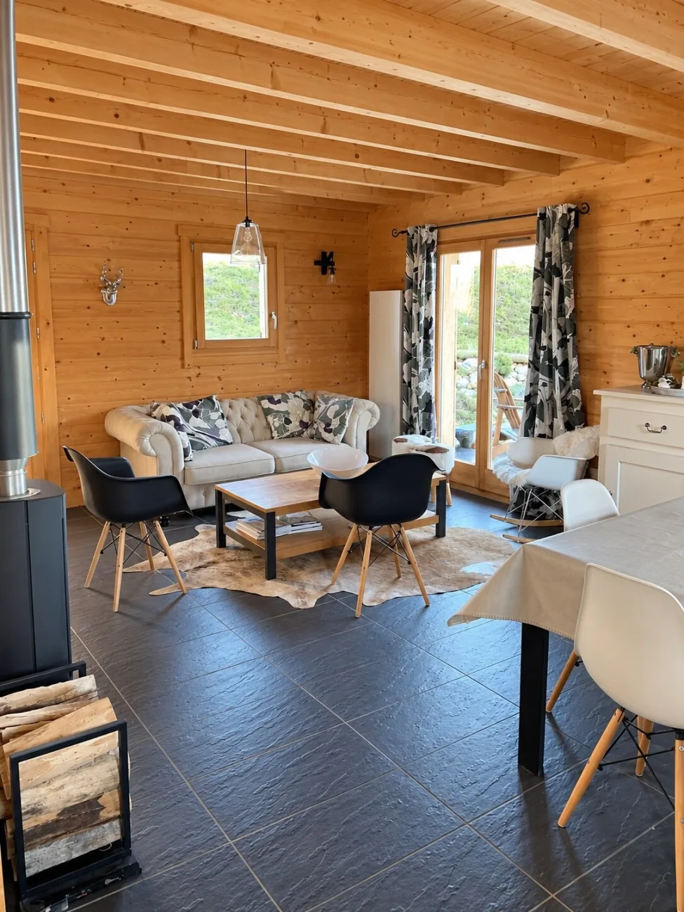 Salon avec poêle à bois, canapé et coin repas