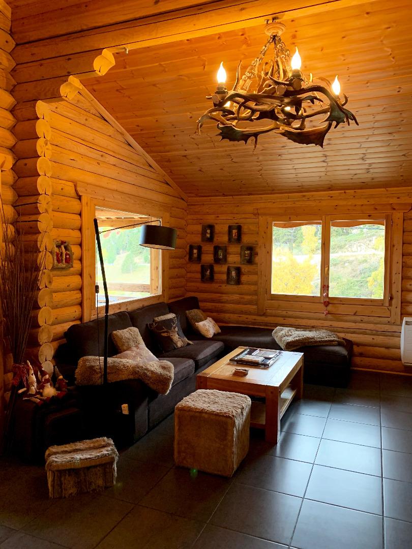 SEJOUR 
Ambiance cocooning du canapé méridienne en velours chocolat avec ses plaids et coussins en fausse fourrure. Poêle à bois d'une efficacité remarquable. Déco très nature, trophées,luminaire en bois d'élan. Téléviseur LiveBox décodeur Orange.