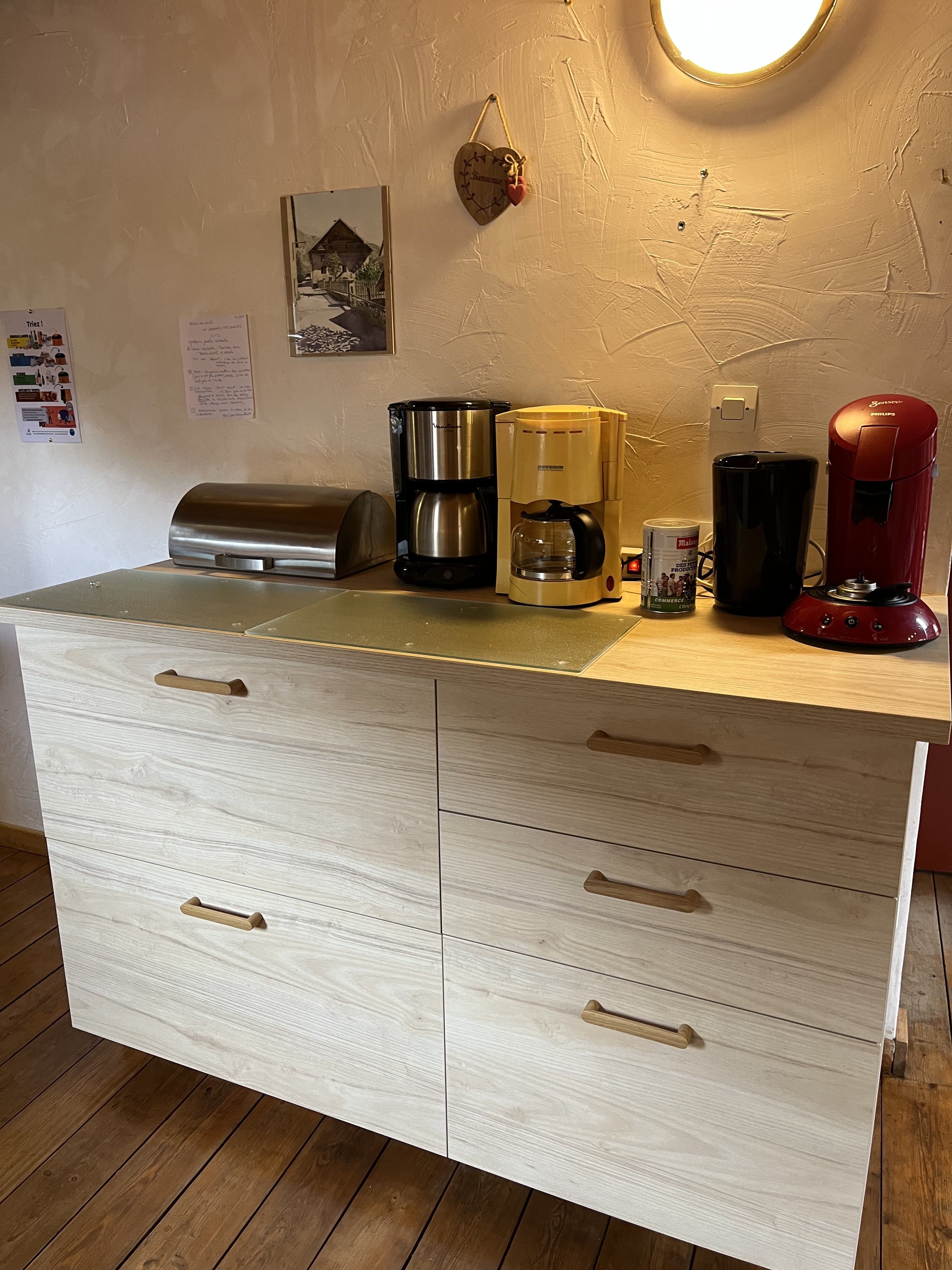 Dans la cuisine, un cassserolier avec la vaisselle et les casseroles. Cafetière senséo, 2 cafetières, 1 bouilloire. Petit matériel électroménager: mixer plongeant, robot. 