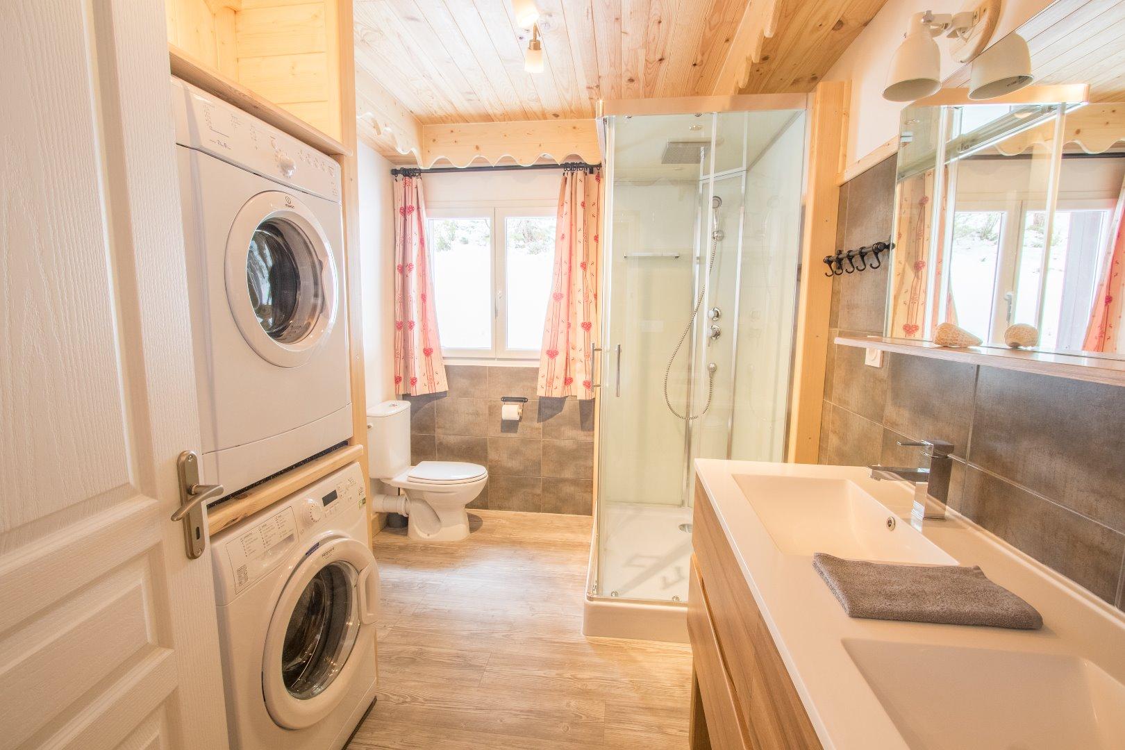 salle de douche avec double vasque et coin buanderie.