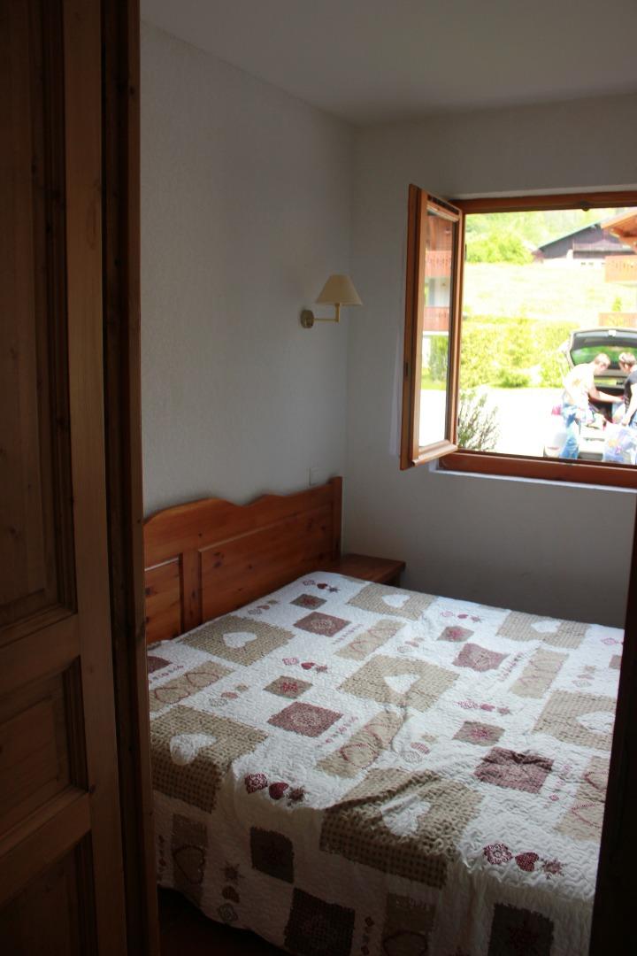 chambre avec un lit de 160, 1 placard de rangement et 2 tables de nuit. Elle donne sur le parking avec une fenêtre ouvrante