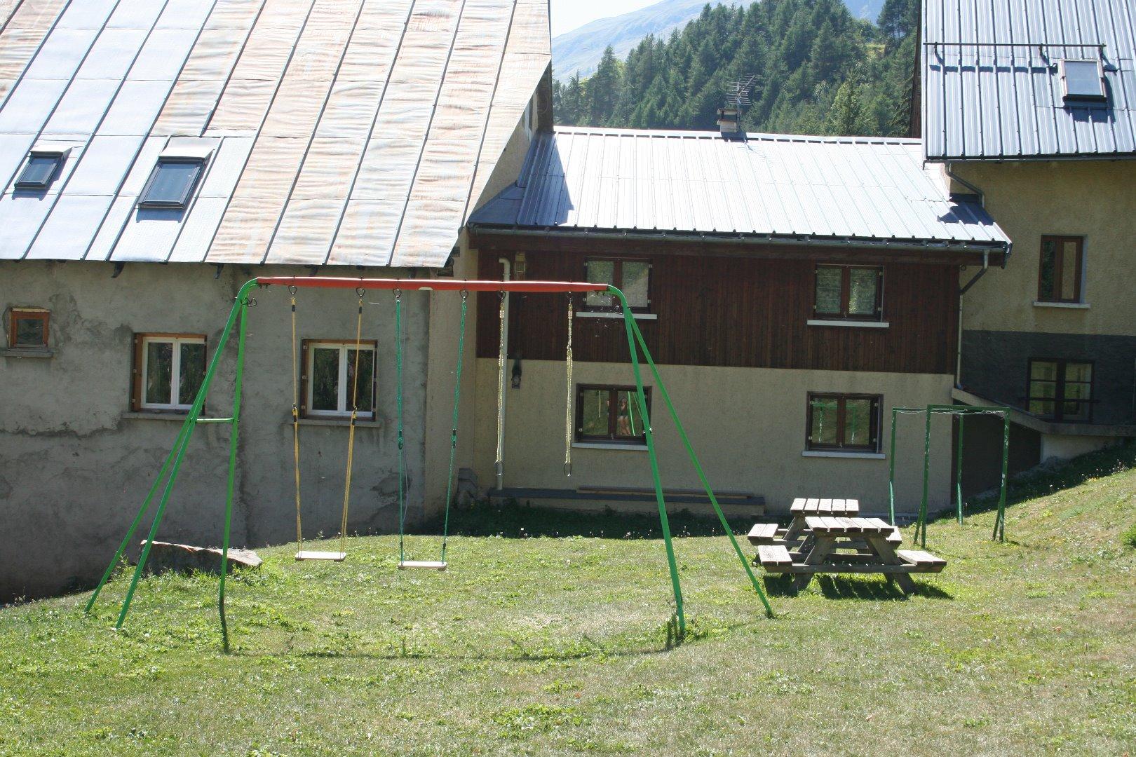 Jardin avec balançoire et tables de pique-nique pour l'été