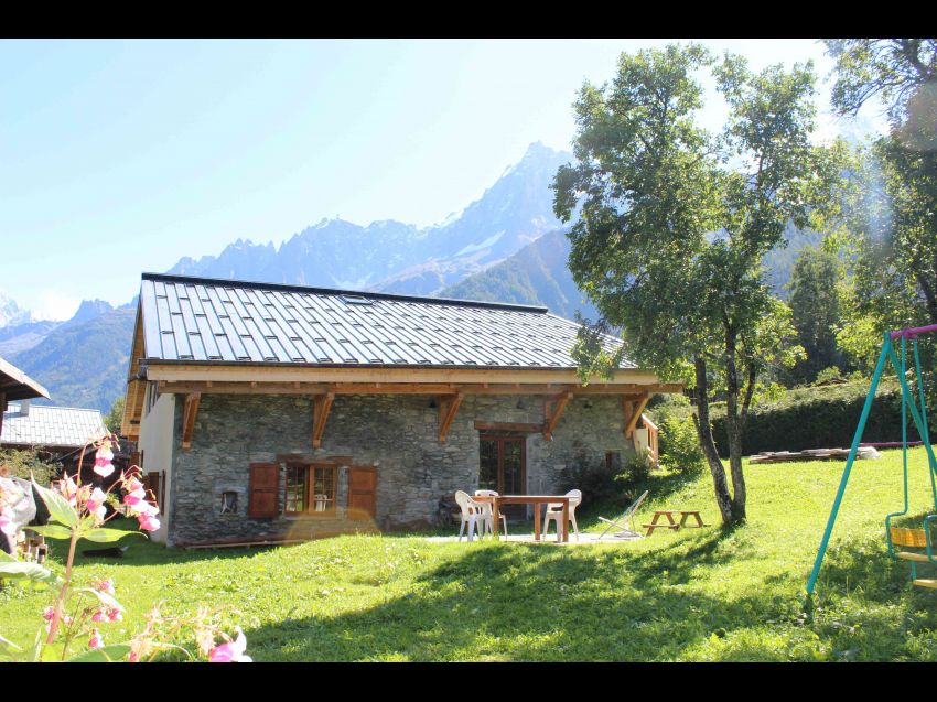 En été, portique , jardin privatif, tables de jardin et vue sur les aiguilles de Chamonix.