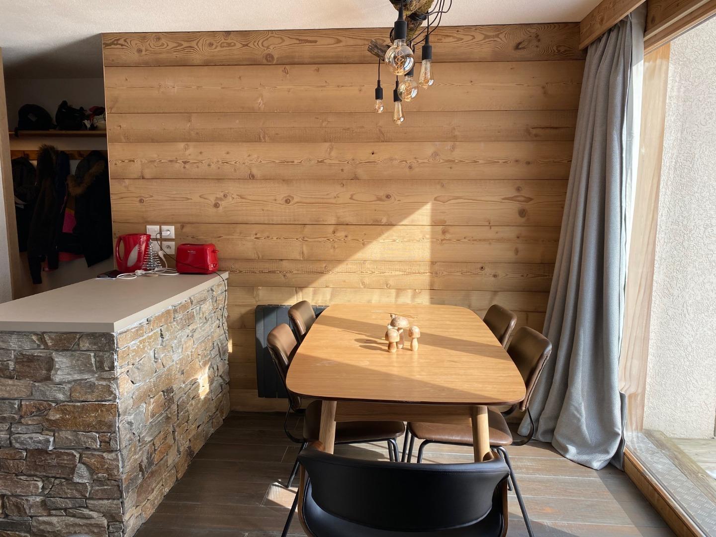 La salle à manger, l'ilot et l'entrée en arrière plan